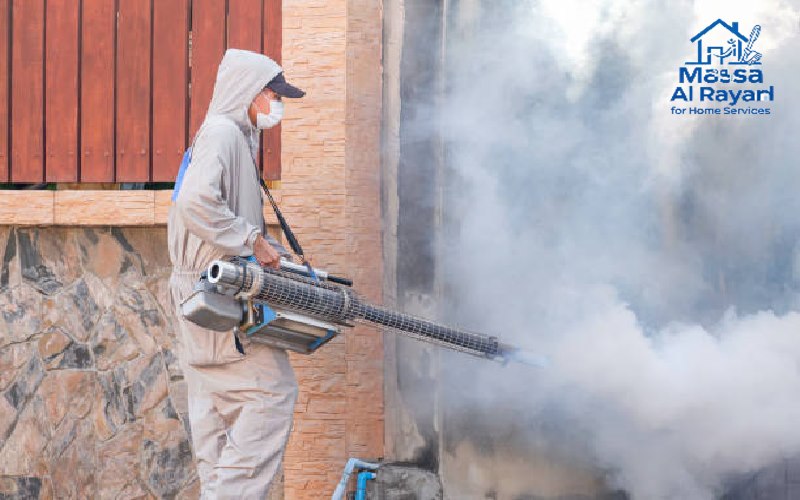 شركة مكافحة حشرات ورش المبيدات برماح 3 عامل مكافحة حشرات ميداني يستخدم جهاز رش مبيدات حشرية لإزالة البعوض والسيطرة على وباء حمى الضنك في منطقة مهجورة بجوار سور منزل