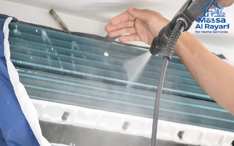 فني يستخدم ماكينة غسيل بالضغط لتنظيف زعانف ملف التبريد في مكيف مركزي