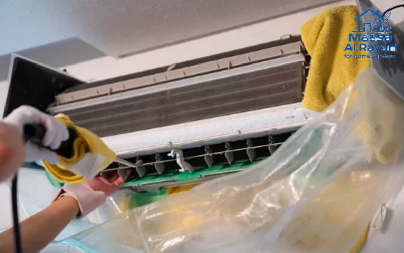 فني متخصص في شركة تنظيف مكيفات شرق الرياض يستخدم جهاز الضغط العالي لتنظيف المبادلات الحرارية