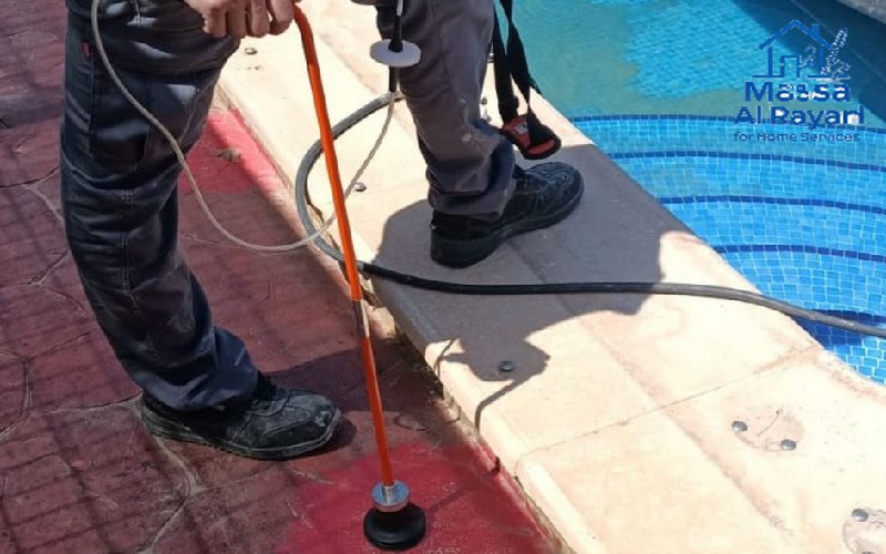 فني يقوم بفحص مسبح لكشف تسربات المياه في الفيلا بالرياض