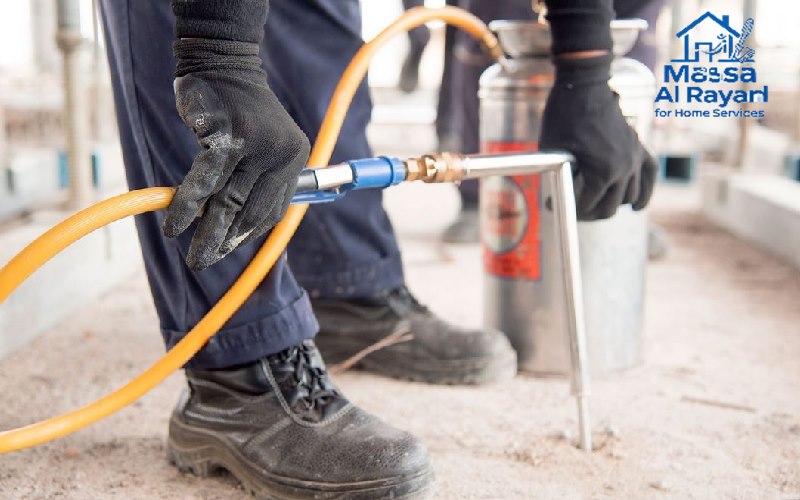 كيف تتخلص من النمل الأبيض (الأرضة) في المنزل؟ | دليل شامل مع الحلول الفعالة 4 فني متخصص في مكافحة النمل الابيض يقوم بحقن التربة حول أساسات المنزل بمبيدات معتمدة لإنشاء حاجز وقائي